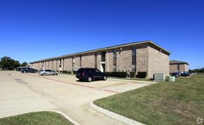Port Arthur apartment for rent - a long brick building with cars parked in front of it
