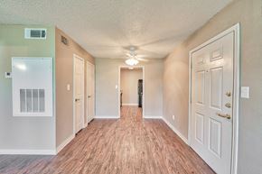 Port Arthur apartment for rent - an empty hallway with a ceiling fan and white doors