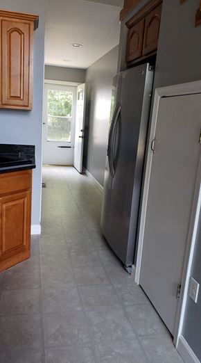 Girdletree house for rent - A kitchen with a refrigerator and wooden cabinets.