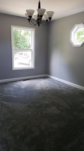 Girdletree house for rent - A room with a grey carpet and a chandelier.