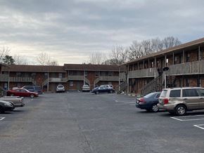 Winston Salem apartment for rent - a parking lot filled with cars in front of a building