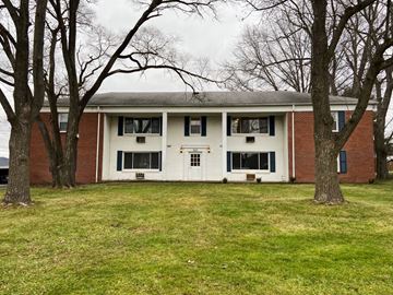 Akron apartment for rent - a white and brick building with trees in front of it