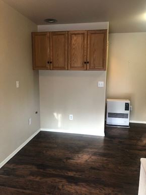 Kasilof house for rent - an empty living room with wooden floors and cabinets