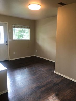 Kasilof house for rent - an empty room with wooden floors and a window