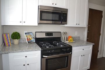St. Louis Park apartment for rent - a kitchen with white cabinets and a stove and a microwave