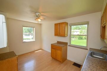 Cincinnati apartment for rent - A kitchen with wooden cabinets and a ceiling fan.