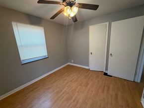 Cincinnati apartment for rent - A room with a ceiling fan and wooden flooring.