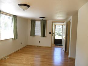 Kenai apartment for rent - A room with wooden floors and a doorway leading to another room.
