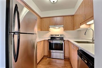 Brossard apartment for rent - a kitchen with wooden cabinets and stainless steel appliances