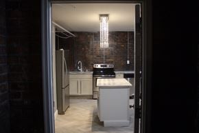 Detroit apartment for rent - A kitchen with a refrigerator, sink, and cabinets.