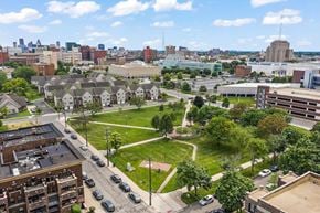 Detroit apartment for rent - A cityscape with buildings, cars, and a green park area.