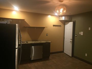 Detroit apartment for rent - A kitchen with a black refrigerator and a white door.