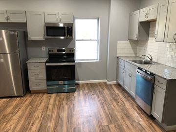 St. Louis apartment for rent - an empty kitchen with wood floors and stainless steel appliances