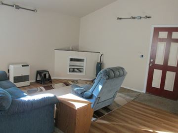 Soldotna apartment for rent - A living room with a blue couch and a grey armchair.