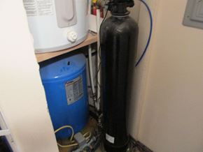 Soldotna apartment for rent - A black gas cylinder is connected to a blue container with a hose.