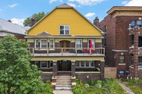 Detroit apartment for rent - the front of a house with a yellow facade and a balcony