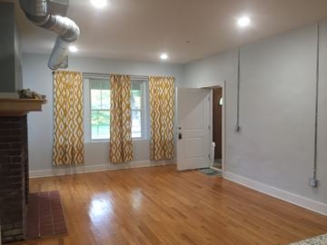 Detroit apartment for rent - a living room with a fireplace and yellow curtains