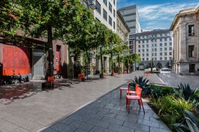 San Francisco apartment for rent - a city street with red chairs and trees and buildings