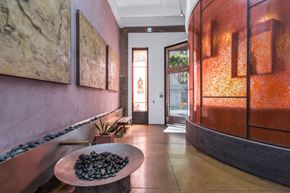 San Francisco apartment for rent - a hallway with pink walls and a table with rocks