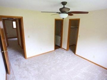 Rantoul apartment for rent - an empty living room with a ceiling fan and three doors