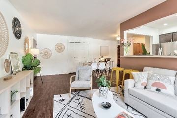 Ferndale apartment for rent - A living room with a white couch, a grey armchair, a coffee table, and a rug with a black and white design.