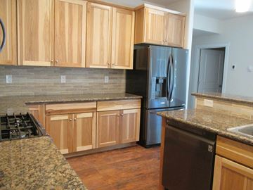 Soldotna apartment for rent - A kitchen with wooden cabinets and a black refrigerator.