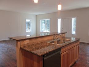 Soldotna apartment for rent - A kitchen with a granite countertop and wooden cabinets.