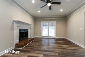 Snellville house for rent - a living room with a fireplace and a ceiling fan