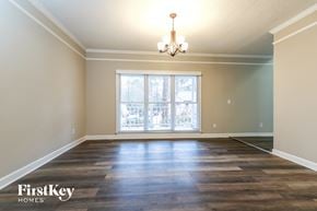 Snellville house for rent - an empty living room with a window and a chandelier
