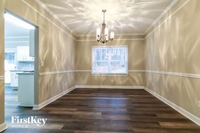 Snellville house for rent - an empty dining room with a window and a chandelier