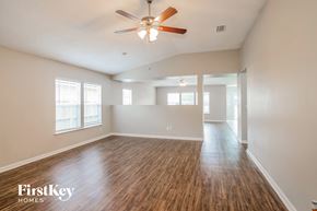 Jacksonville house for rent - A spacious room with a wood floor and a ceiling fan.