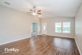 Jacksonville house for rent - A room with wooden floors and a ceiling fan.