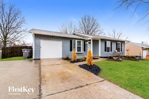 O'fallon house for rent - a blue house with a driveway and a white garage door