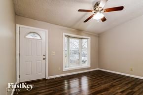 O'fallon house for rent - an empty living room with a ceiling fan and a white door