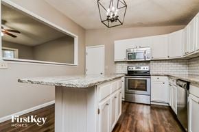 O'fallon house for rent - a kitchen with white cabinets and a marble counter top