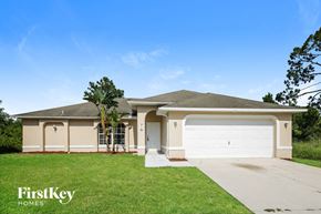 Lehigh Acres house for rent - a house with a white garage door and a lawn