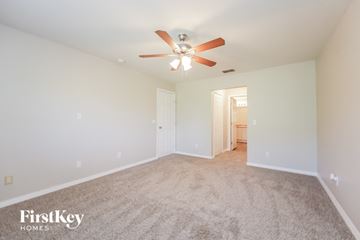 Lehigh Acres house for rent - a spacious living room with carpet and a ceiling fan