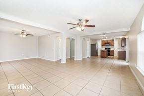 Poinciana house for rent - a spacious living room with tile flooring and a ceiling fan