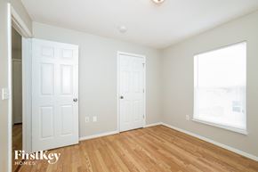 Poinciana house for rent - a bedroom with two doors and a window and a wood floor
