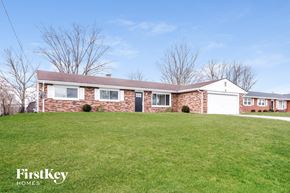 Trenton house for rent - A brick house with a white garage door and a green lawn.