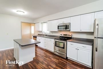 Trenton house for rent - A kitchen with white cabinets and a wooden floor.