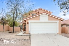Tucson house for rent - a home with a white garage door in front of it