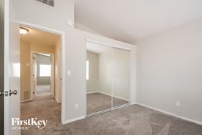 Tucson house for rent - a bedroom with a large mirror and carpeted flooring