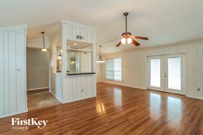 Friendswood house for rent - A spacious room with wooden floors and a ceiling fan.