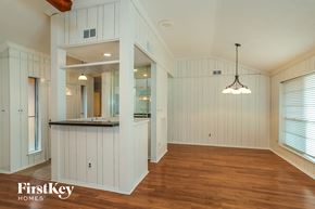 Friendswood house for rent - A spacious room with wooden floors and white walls.