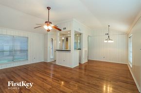 Friendswood house for rent - A spacious room with wooden floors and a ceiling fan.