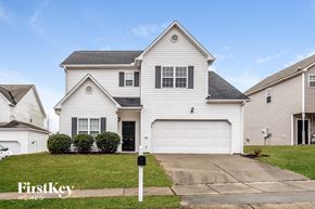 Fuquay-Varina house for rent - A white house with a black door and a garage door.