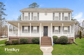 Durham house for rent - A white two-story house with a porch and a black door.