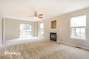 Durham house for rent - A spacious living room with a fireplace and a ceiling fan.