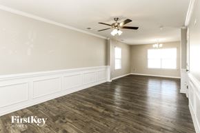 Charlotte house for rent - A spacious room with wooden floors and a ceiling fan.